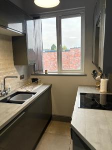 a kitchen with a sink and a window at Impressive City Centre Apartment in Derby