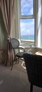 a room with a chair and a window at Hotel Penzance Promenade in Penzance