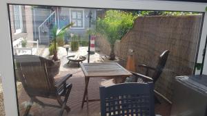 a patio with a table and chairs on a deck at Bastan - Haus Katharina in Emden