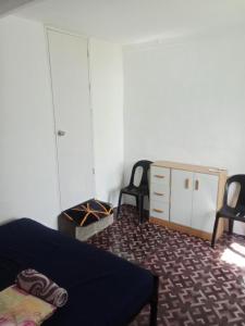 a bedroom with a bed and two chairs and a dresser at MountainSide Lodge in El Nido