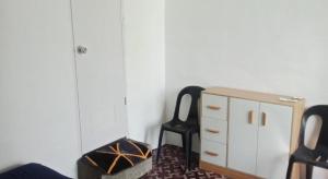 a bedroom with a dresser and a black chair at MountainSide Lodge in El Nido +2 photos