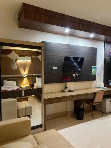 a room with a desk with a television and a bed at Toba Village Inn in Tuktuk Siadong