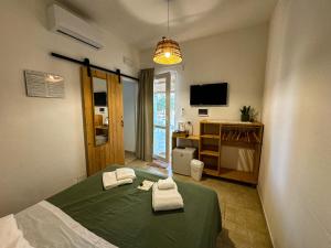 a bedroom with a green bed and a television at Trullo Moi in Ostuni