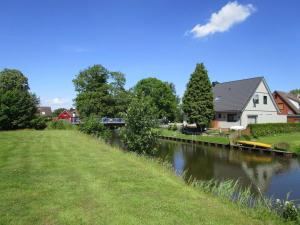 a river with a house and a bridge on the side at Ferienwohnung Biesterfeld in Bedekaspel