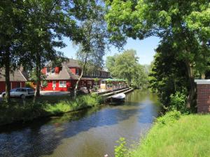 a river with a house and a boat on it at Ferienwohnung Biesterfeld in Bedekaspel