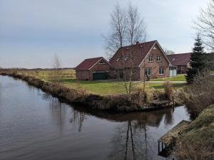 a house on the side of a river at Ferienwohnung Biesterfeld in Bedekaspel +8 photos