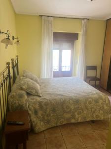 a bedroom with a bed and a table and a window at Casa Gloria in Sasamón