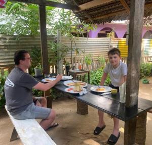 a man and a boy sitting at a picnic table at Echo Point in Trincomalee