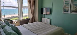 a bedroom with a bed and a view of the ocean at Hotel Penzance Promenade in Penzance