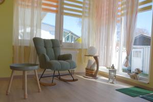a living room with a chair and a window at Ferienhaus An der Riede in Bedekaspel