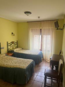 a hotel room with two beds and a piano at Casa Gloria in Sasamón