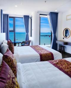 a hotel room with two beds and a view of the ocean at Gia Kiên Hotel in Quy Nhon