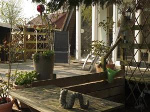 a wooden bench sitting on a porch with plants at Ladwig - Ferienhaus Adda in Südbrookmerland