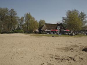 a sandy beach with a building in the background at Ladwig - Ferienhaus Adda in Südbrookmerland