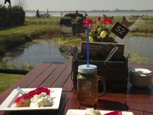 a table with a plate of food and a drink at Ladwig - Ferienhaus Adda in Südbrookmerland +28 photos