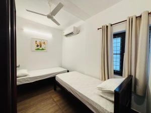 a room with two beds and a window at Fort Grande INN in Fort Kochi