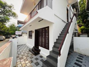 a house with a staircase leading to the front door at Fort Grande INN in Fort Kochi