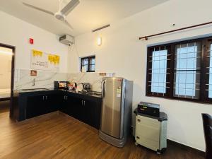 a kitchen with a stainless steel refrigerator in a room at Fort Grande INN in Fort Kochi