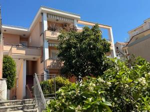 an apartment building with a tree in front of it at SS Pearl Apartment 1 in Utjeha