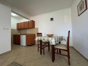 a kitchen with a table and chairs and a kitchen with a refrigerator at SS Pearl Apartment 1 in Utjeha