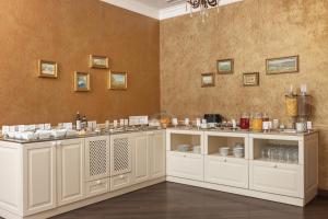 a kitchen with white cabinets and a wall at Alexandrovskiy Hotel in Odesa +60 photos