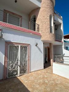 a white house with a gate in front of it at Villa Élégance in Tunis
