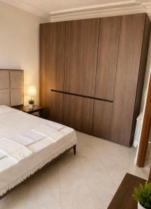 a bedroom with a bed and a large wooden cabinet at Villa Élégance in Tunis