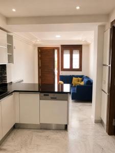 a kitchen and living room with a blue couch at Villa Élégance in Tunis +6 photos
