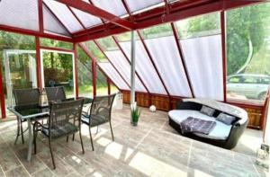 a screened in porch with a bed and a table and chairs at Natur Hof Fehmarn in Fehmarn