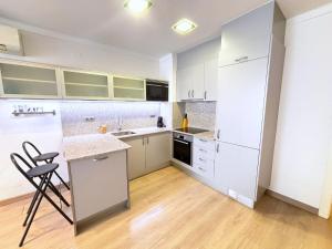 a kitchen with white cabinets and a counter top at Rhode 1b in Roses