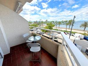 a balcony with a table and chairs and the beach at Rhode 1b in Roses +14 photos