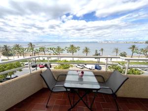a balcony with a table and chairs and the ocean at Rhode 2a in Roses