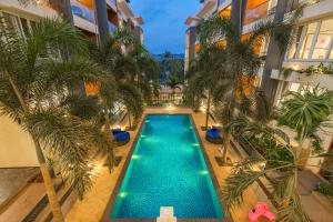 an overhead view of a swimming pool in a building with palm trees at Perfectstayz Premium Carnival Suites Near Candolim in Pilerne