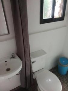 a bathroom with a white toilet and a sink at MountainSide Lodge in El Nido