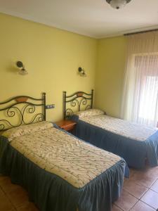 a bedroom with two beds and a window at Casa Gloria in Sasamón