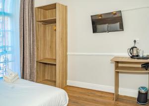 a room with a bed and a desk and a book shelf at Iveagh Lodge in Dublin