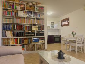 a living room with a large book shelf filled with books at El Mar House in Petrovac na Moru