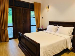 a bedroom with a large bed and a large window at Jungle Breeze Villa in Melsiripura