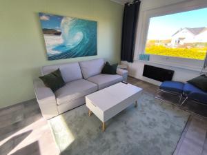 a living room with a couch and a large window at Westerbergen Haus "leucht blick" in Westfehmarn