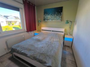 a small bedroom with a bed and a window at Westerbergen Haus "leucht blick" in Westfehmarn