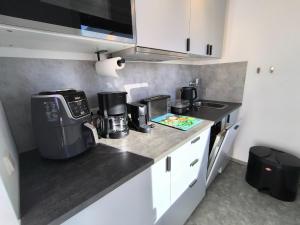 a kitchen counter with a coffee maker and a microwave at Westerbergen Haus "leucht blick" in Westfehmarn