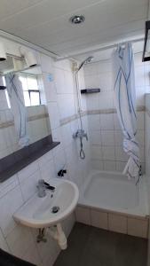 a bathroom with a sink and a bath tub and a sink at Westerbergen Haus "leucht blick" in Westfehmarn +19 photos