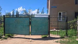 an open gate in front of a building at Belek Gust house in Toktogul