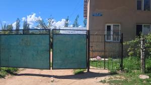 an iron gate in front of a building at Belek Gust house in Toktogul