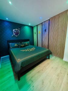 a bedroom with a green bed with a football crest on it at Quartier Général des Gamers Arcade Terrasse in Saint-Omer
