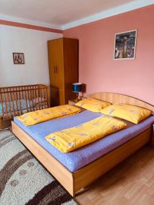 a bedroom with two beds with yellow sheets at Apartmán Kristínka in Lendak