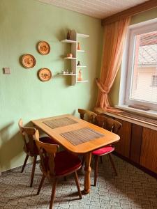 a dining room with a wooden table and chairs at Apartmán Kristínka in Lendak