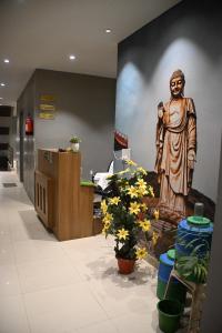 a painting of a statue in a lobby with flowers at Hotel 60 in Bhucho