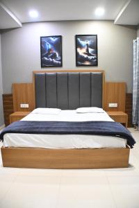 a bedroom with a large bed with three pictures on the wall at Hotel 60 in Bhucho