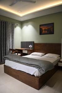 a bedroom with a large bed and a desk at Hotel 60 in Bhucho